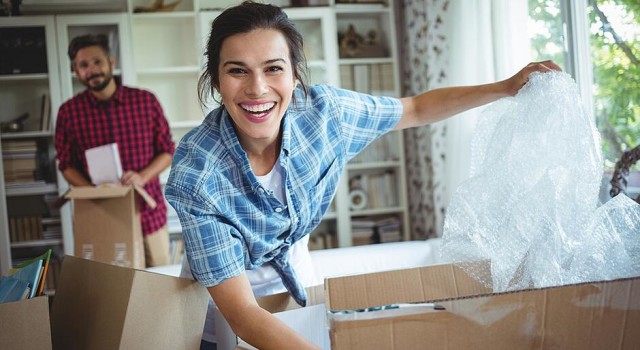 Happy couple unpacking cartons in their new house