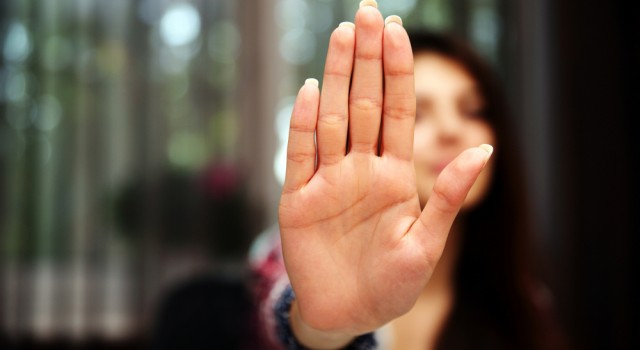 Woman with her hand extended signaling to stop only her hand is in focus